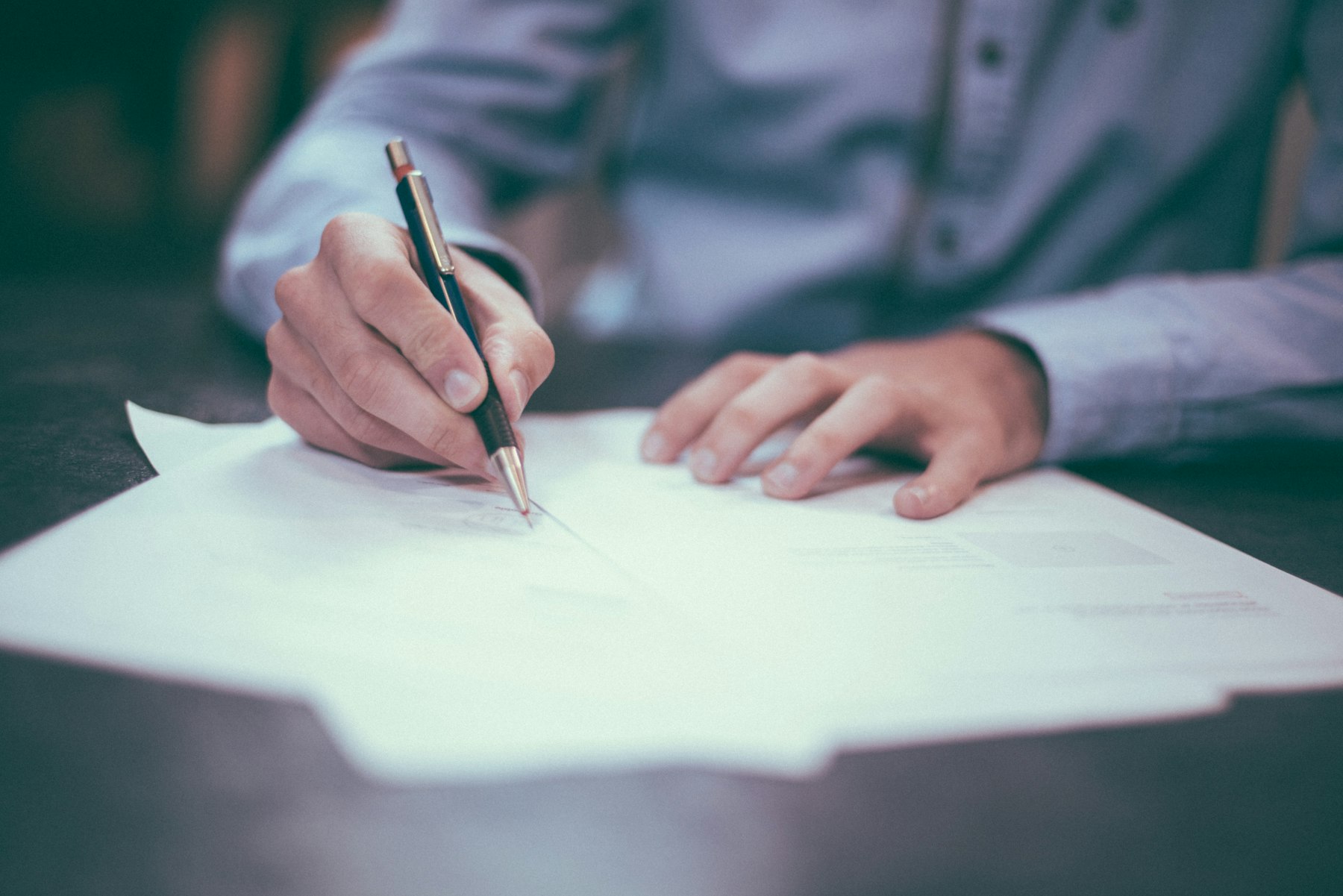 A client signing a proposal with a fountain pen